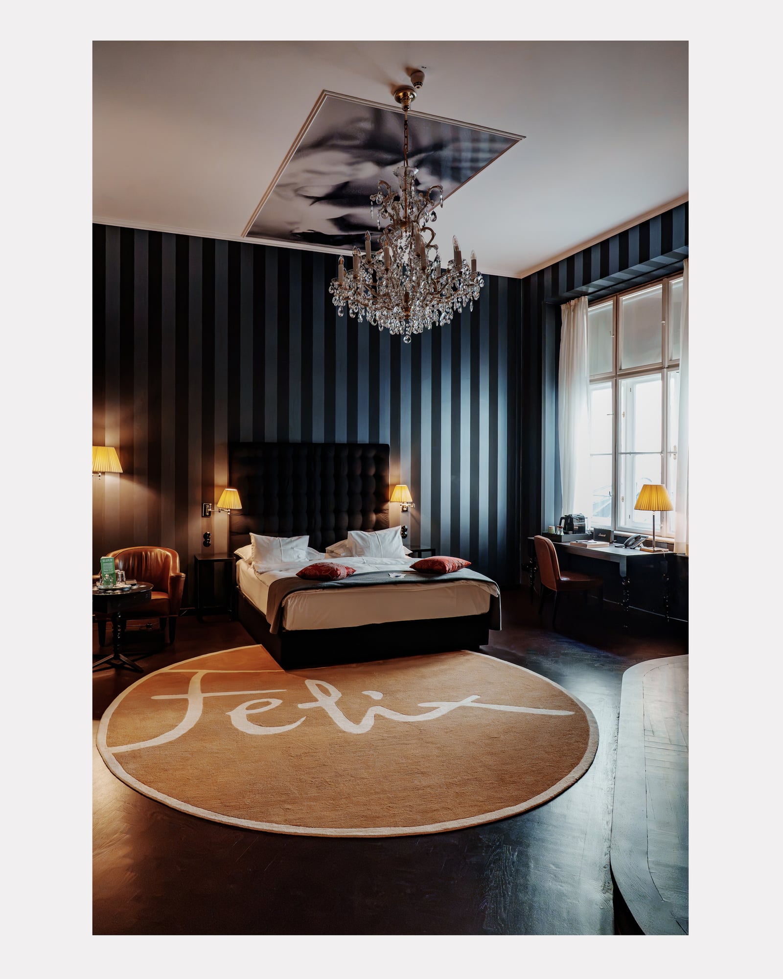 Chambre aux murs rayés sombres, lustre en cristal et tapis rond, hôtel Altstadt Vienna