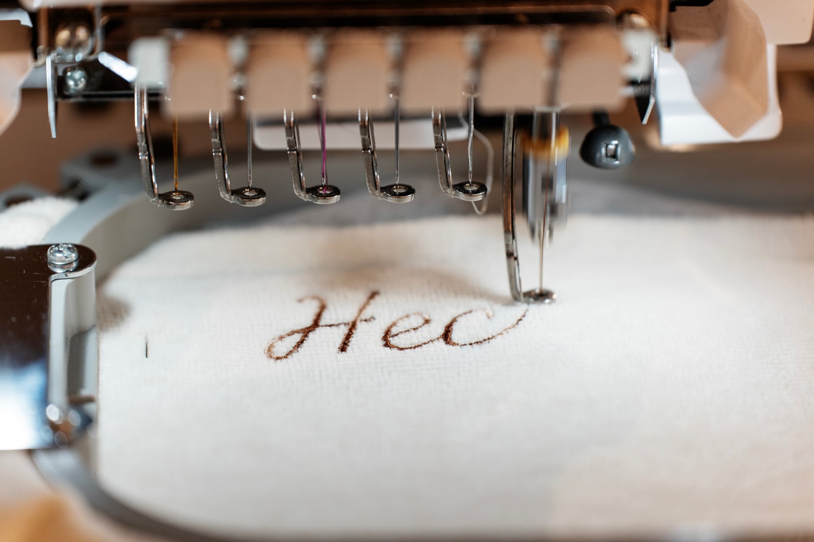 Machine à broder inscrivant « Hej » sur du linge, animation H&M Home