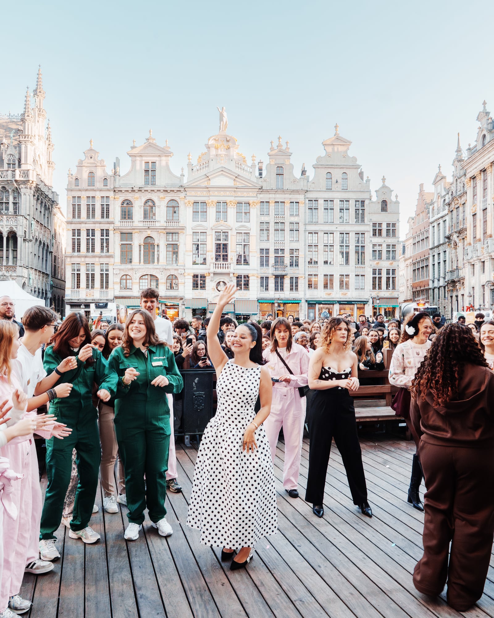 Lena Situations et son équipe sur une estrade face à la Grand-Place de Bruxelles