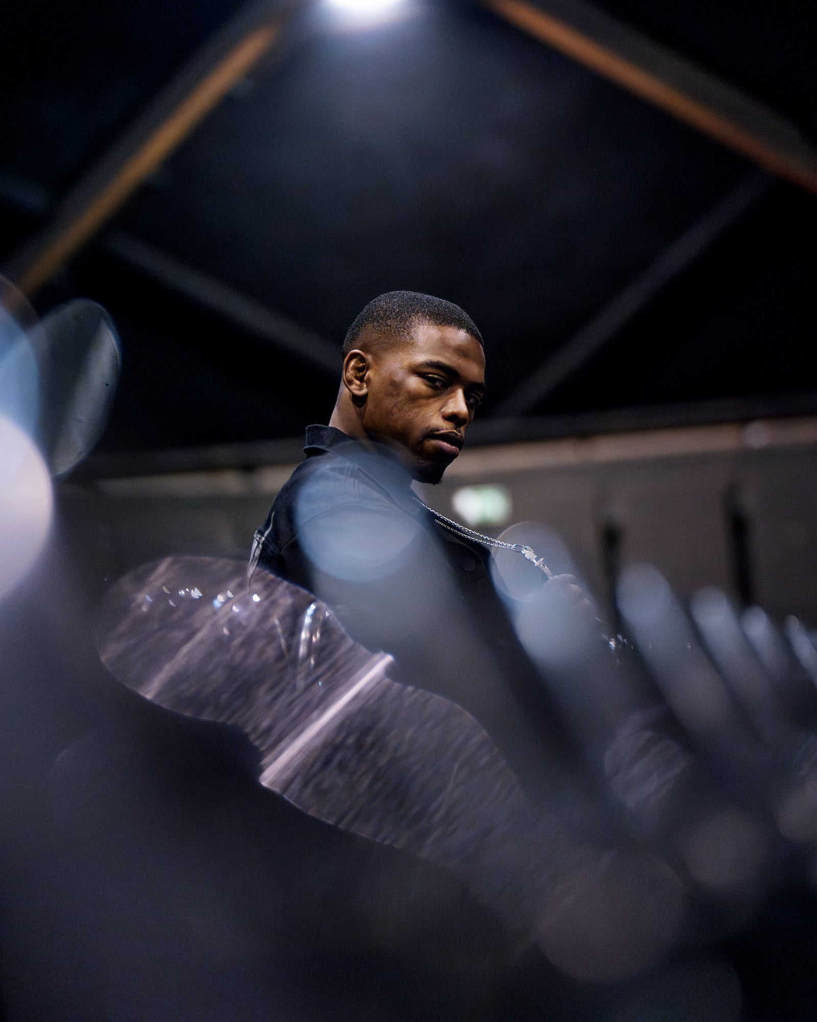 Portrait de Patrick Habirora en veste noire entre les rangées de sièges d'une salle de spectacle